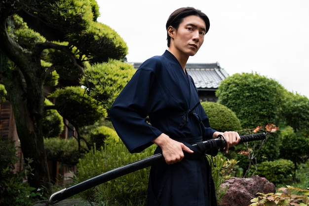 Young asian man with samurai sword