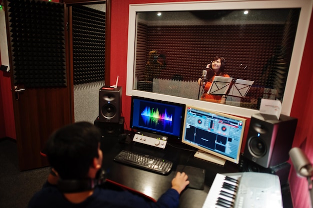 사운드 프로듀서와 함께 녹음 음악 스튜디오에서 마이크 녹음 노래를 가진 젊은 아시아 가수