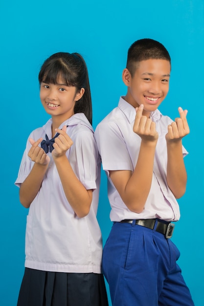 Young Asian students and Asian male students stand together on a blue .