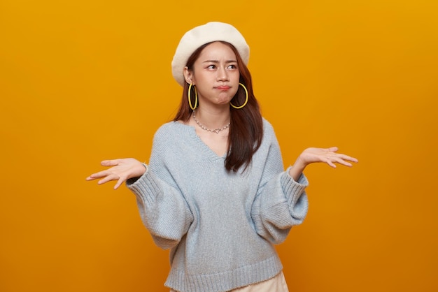 Young Asian teenage girl standing with raised hands and indignant face asking why annoyed by problem