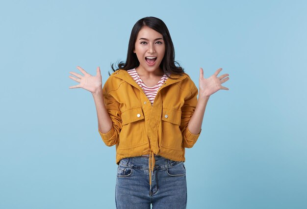 Young Asian teenage girl surprised excited isolated on blue studio background