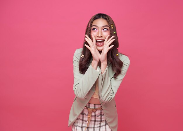 Young Asian teenage girl surprised excited isolated on pink background