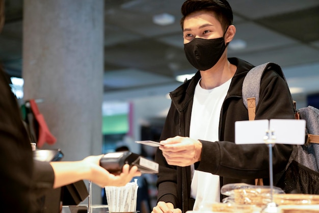 Free photo young asian traveller female sit relax facial expression hand use smartphone waiting for aboard time in cafe restaurant at airport departure terminal