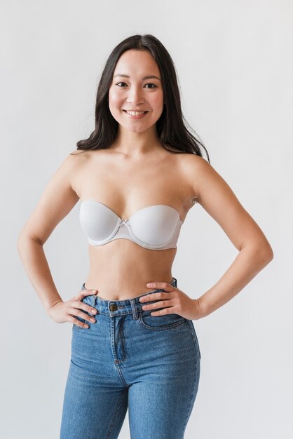 Young asian woman in bra and jeans