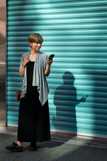 Young asian woman checking her phone outdoors