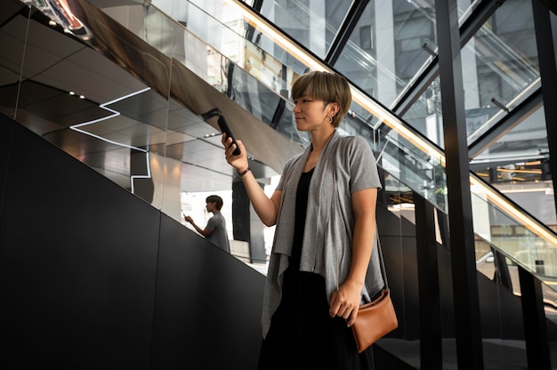 Free photo young asian woman checking her phone