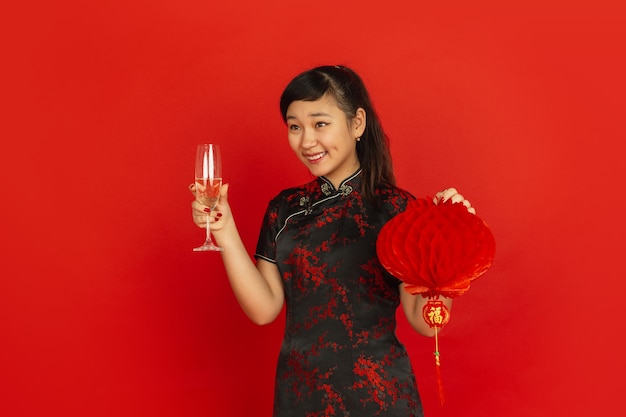 Молодая азиатская женщина пьет шампанское и держит фонарь