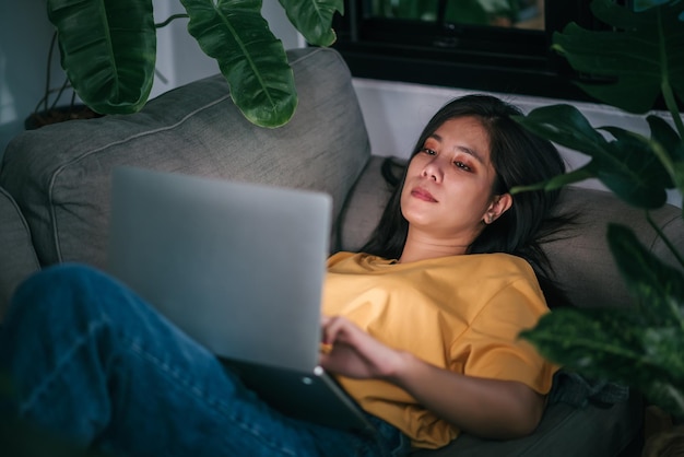 Young asian woman freelancer working at night in living room while work at home mental health health care concept