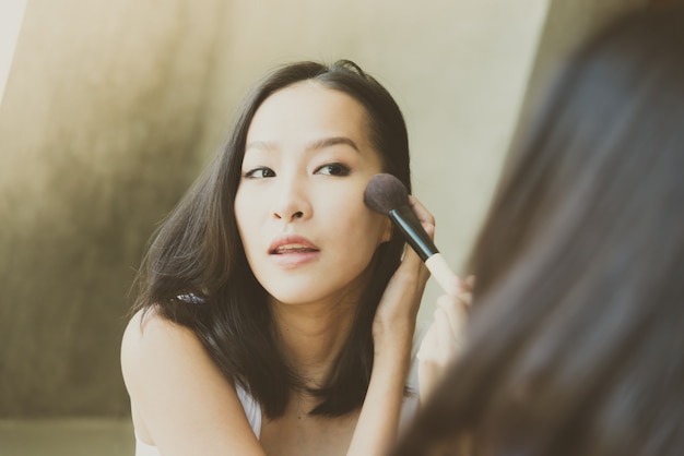 Free photo young asian woman make up yourself