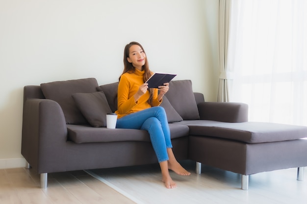 Young asian woman reading book on sofa