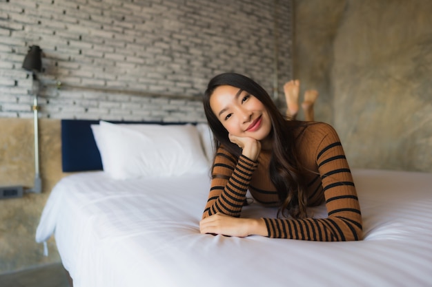 Free photo young asian woman relaxes on bed