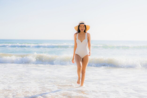 Молодая азиатская улыбка женщины на пляже