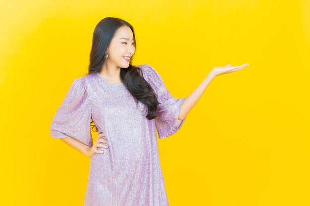 young asian woman smiling on yellow