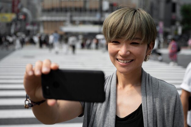 Free photo young asian woman taking a selfie