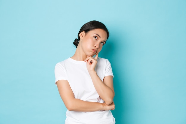 カジュアルなTシャツのポーズを着て若いアジアの女性