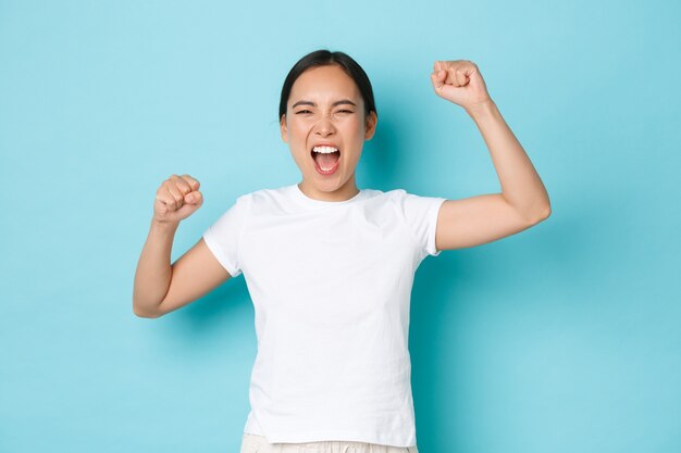 カジュアルなTシャツのポーズを着て若いアジアの女性