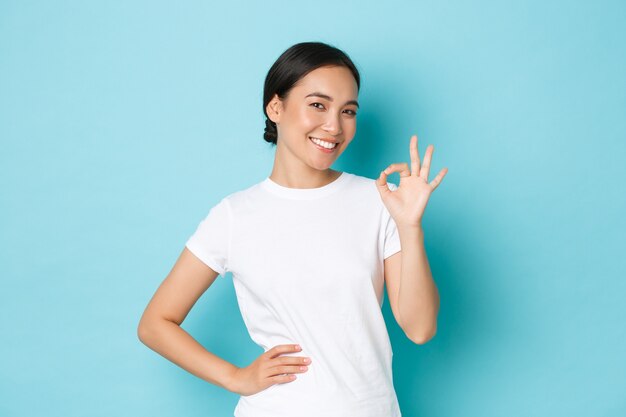 Молодая азиатская женщина в повседневной футболке позирует