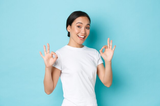 カジュアルなTシャツのポーズを着て若いアジアの女性