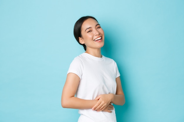 カジュアルなTシャツのポーズを着て若いアジアの女性