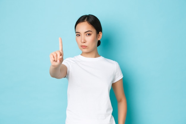 カジュアルなTシャツのポーズを着て若いアジアの女性