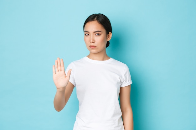 カジュアルなTシャツのポーズを着て若いアジアの女性