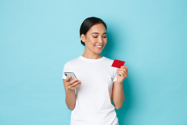 カジュアルなTシャツのポーズを着て若いアジアの女性