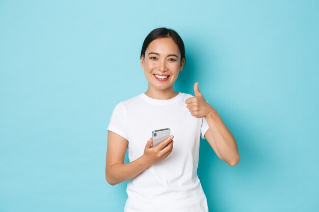 カジュアルなTシャツのポーズを着て若いアジアの女性