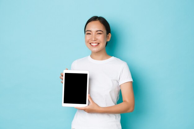 カジュアルなTシャツのポーズを着て若いアジアの女性