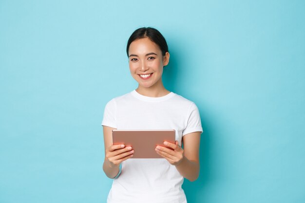 カジュアルなTシャツのポーズを着て若いアジアの女性