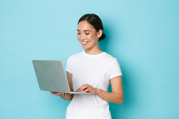 カジュアルなTシャツのポーズを着て若いアジアの女性