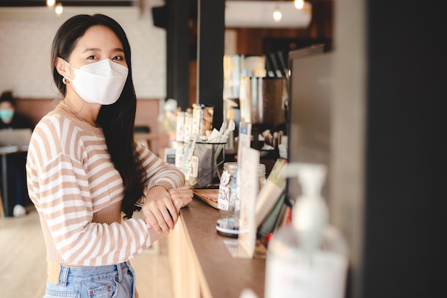 도시에 사는 새로운 정상적인 생활을 위해 외과용 안면 마스크를 쓴 젊은 아시아 여성