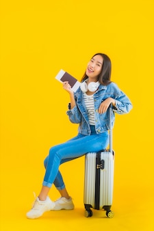 짐 가방과 여권을 가진 젊은 아시아 여성