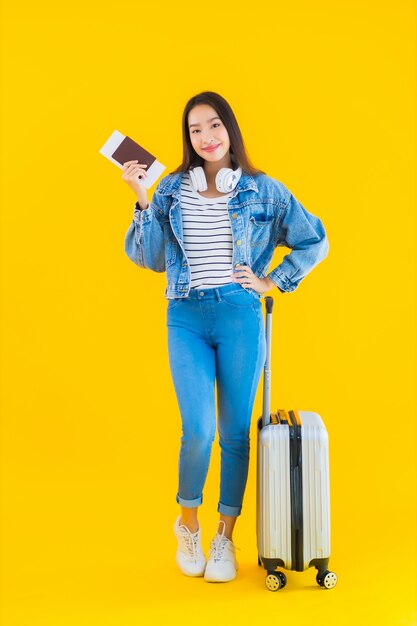 荷物バッグとパスポートを持つ若いアジア女性