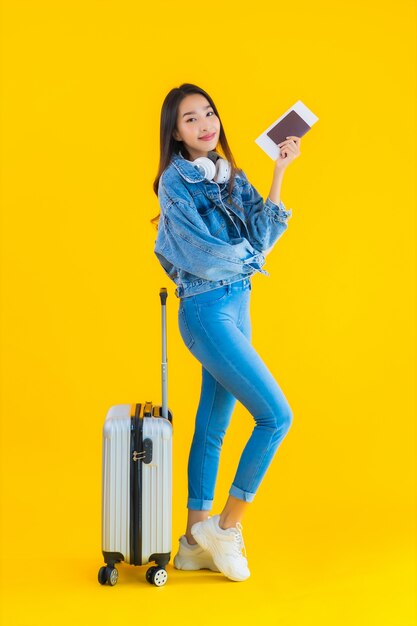 молодая азиатская женщина с чемоданом и паспортом