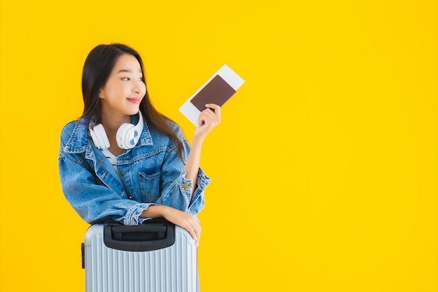 молодая азиатская женщина с чемоданом и паспортом
