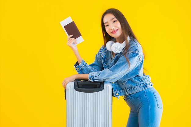 荷物バッグとパスポートを持つ若いアジア女性
