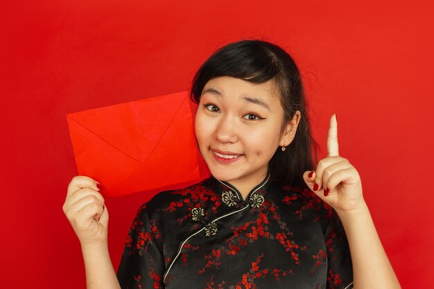 Молодая азиатская женщина с красным конвертом