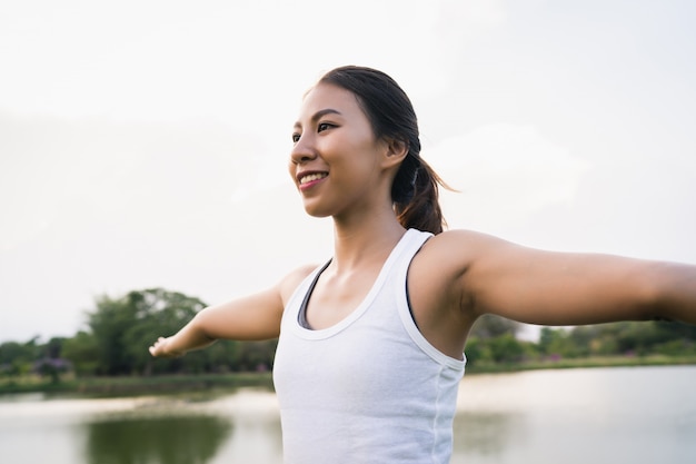 Young asian woman yoga outdoors keep calm and meditates while practicing yoga 