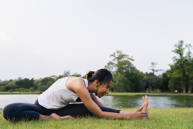 Young asian woman yoga outdoors keep calm and meditates while practicing yoga