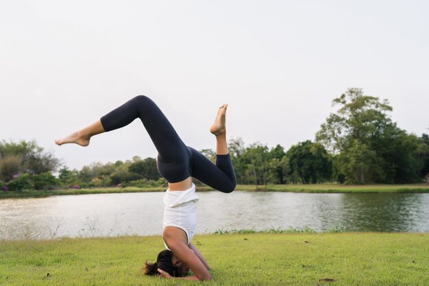 Young asian woman yoga outdoors keep calm and meditates while practicing yoga