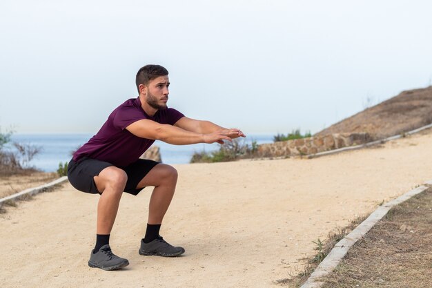 Premium Photo | Young athlete man doing squats outdoor