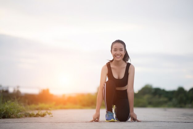 若いアスリートの女性は、ランニングまたはジョギングを開始する準備ができています