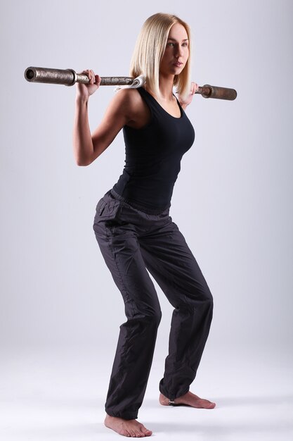 Young athlete woman with exercise bar