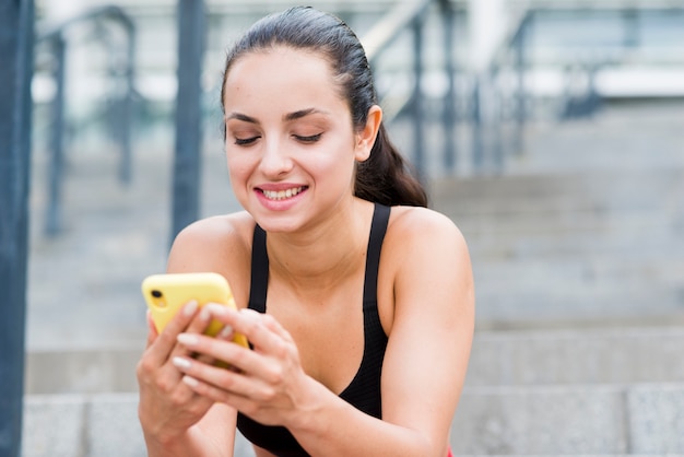 Foto gratuita donna giovane atleta con uno smartphone