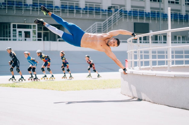 Il giovane uomo atletico esegue gli elementi di ginnastica. uomo che fa esercizio di bandiera umana