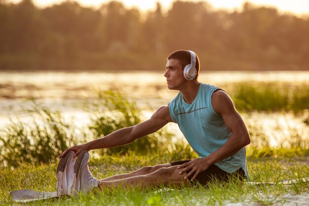 운동하는 젊은 운동 남자, 야외 강변에서 훈련.