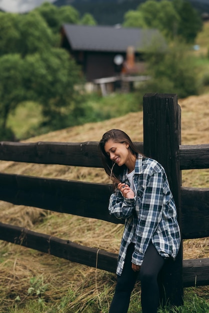 A young attractive Caucasian female stand by a fence