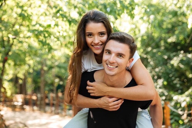 Young attractive couple enjoying piggyback ride