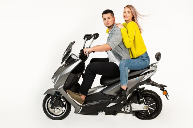 Young attractive couple riding an electric motorbike scooter happy having fun together