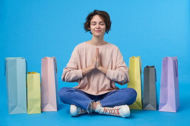 Young attractive dark haired woman with short haircut with a lot of shopping bags